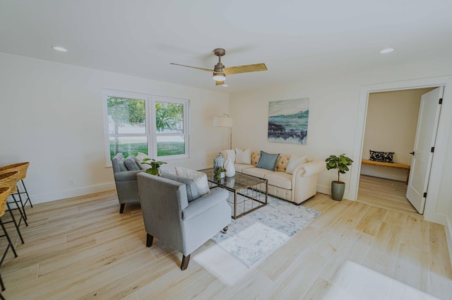 living room with light wood-type flooring and ceiling fan