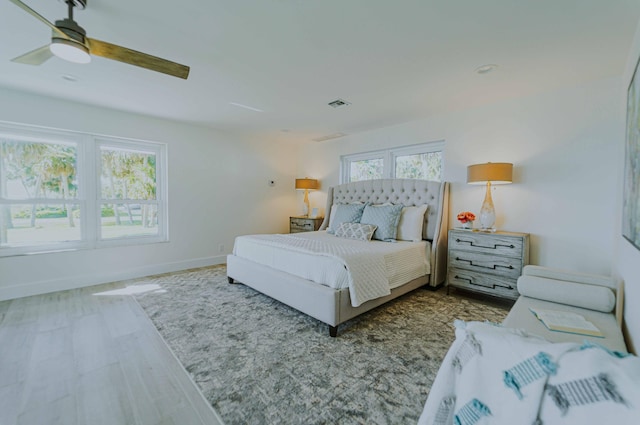 bedroom with wood-type flooring, multiple windows, and ceiling fan