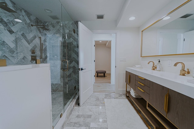 bathroom with a shower with door and vanity