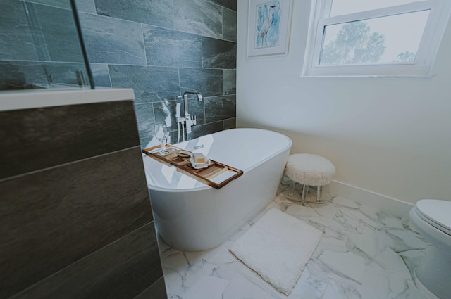 bathroom featuring a washtub, toilet, and tile walls