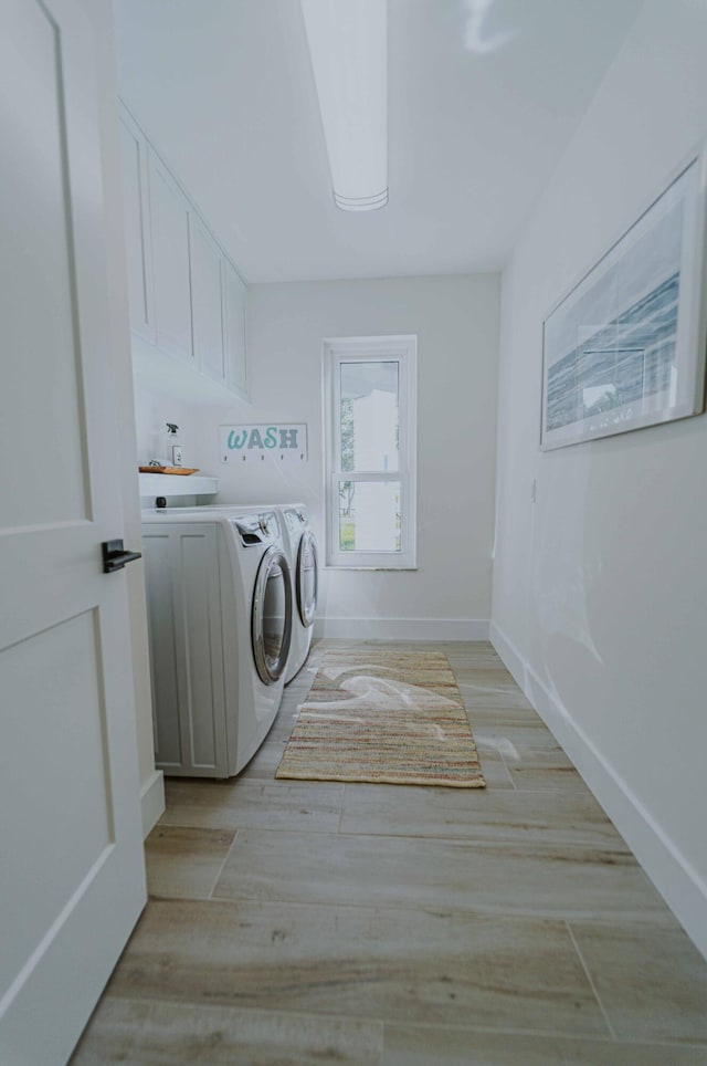 washroom with separate washer and dryer and light wood-type flooring