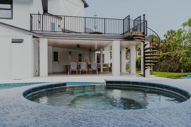 view of swimming pool featuring ceiling fan, a patio area, and a hot tub