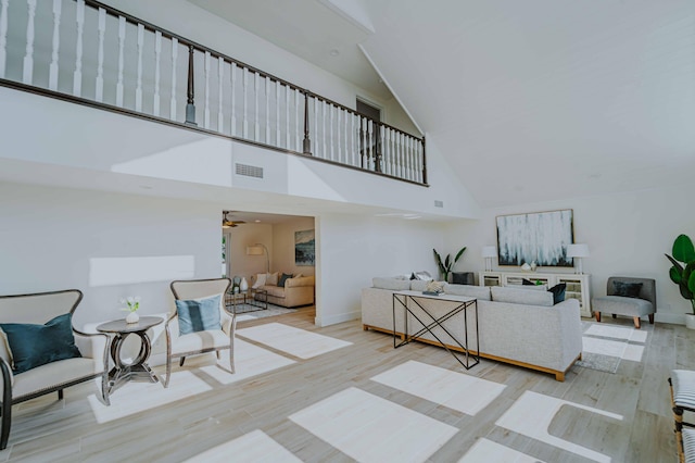 interior space featuring ceiling fan, light hardwood / wood-style floors, and high vaulted ceiling