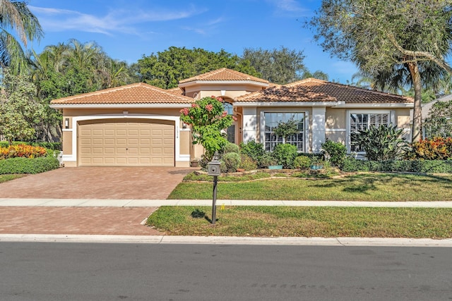 mediterranean / spanish-style home featuring a garage and a front lawn