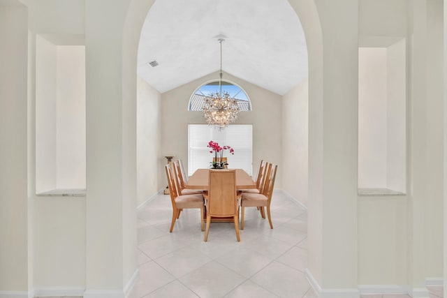 tiled dining area featuring a chandelier and lofted ceiling