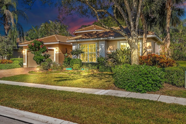 mediterranean / spanish house with a garage and a yard