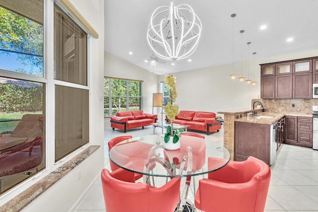 dining space featuring sink, light tile patterned flooring, a chandelier, and lofted ceiling