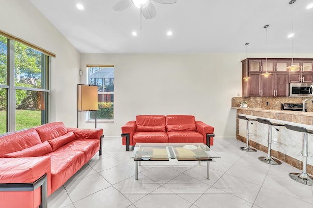 tiled living room with plenty of natural light, lofted ceiling, and ceiling fan