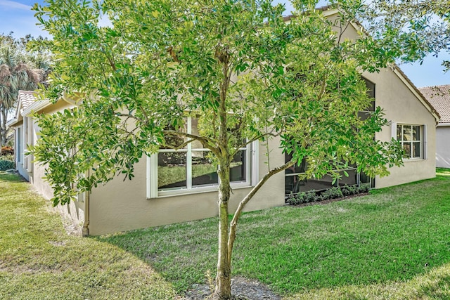 view of side of home with a yard