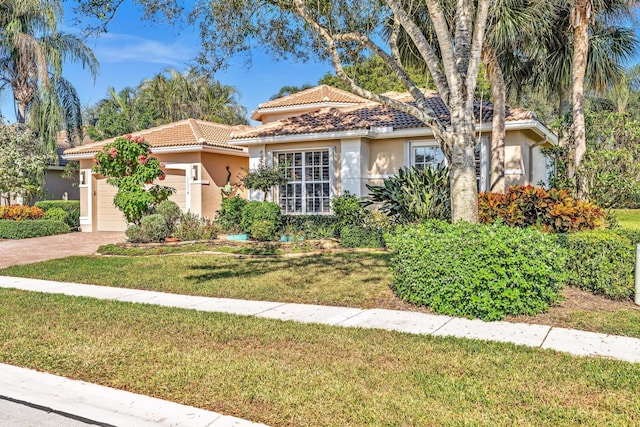 mediterranean / spanish home with a front lawn and a garage