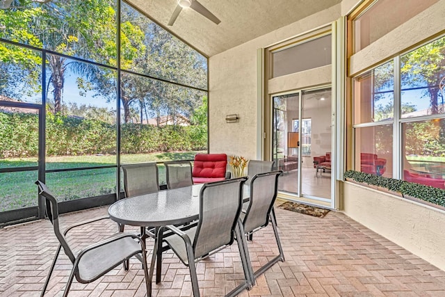 sunroom with ceiling fan and vaulted ceiling