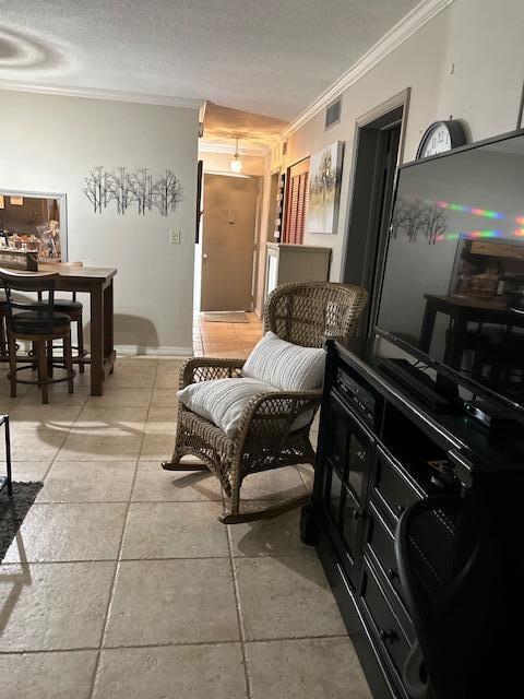 living area with ornamental molding and a textured ceiling