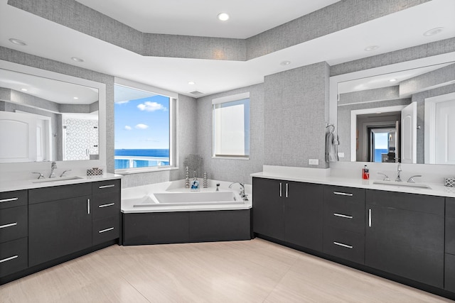 bathroom featuring separate shower and tub, a water view, and vanity