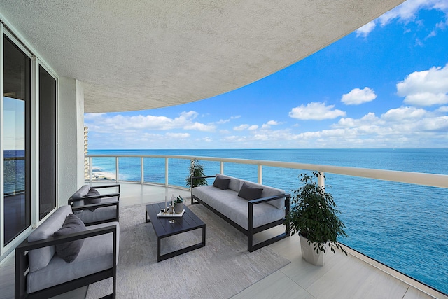 balcony with an outdoor living space and a water view