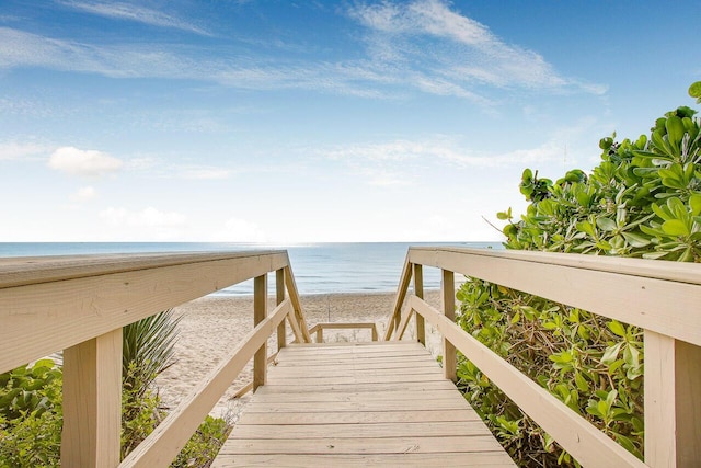 view of property's community featuring a water view and a beach view