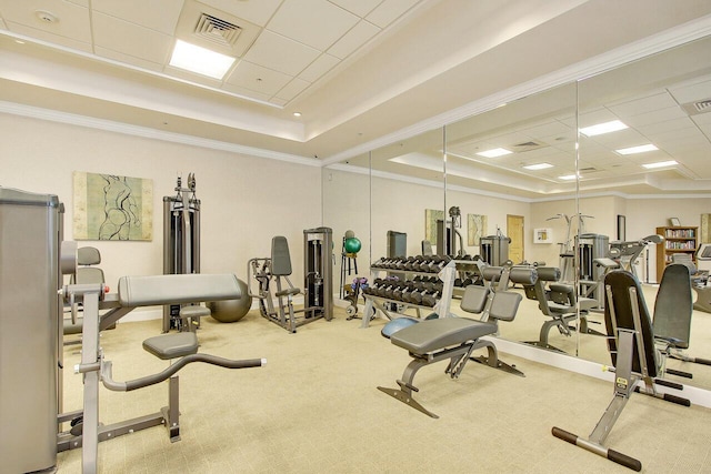 exercise room with a tray ceiling, carpet flooring, and a drop ceiling