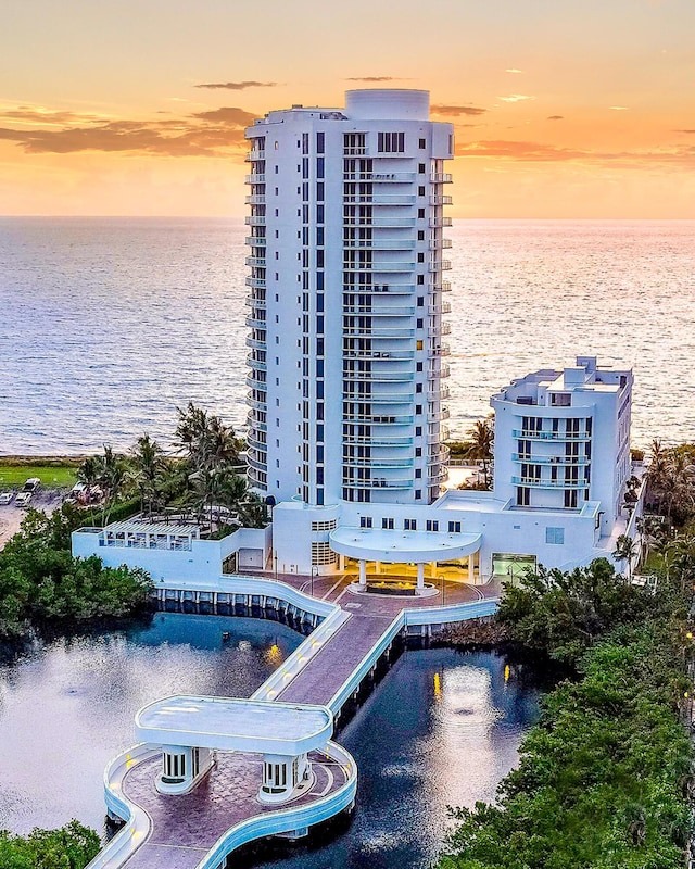 aerial view at dusk featuring a water view