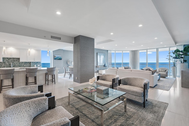 living room featuring floor to ceiling windows and a water view