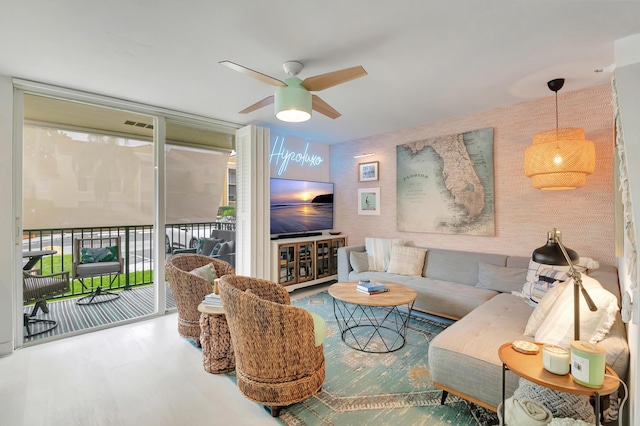 living room with ceiling fan and expansive windows