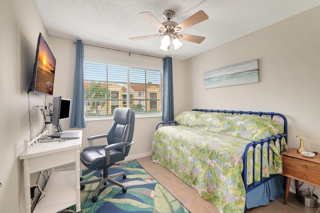 tiled bedroom featuring ceiling fan and a textured ceiling