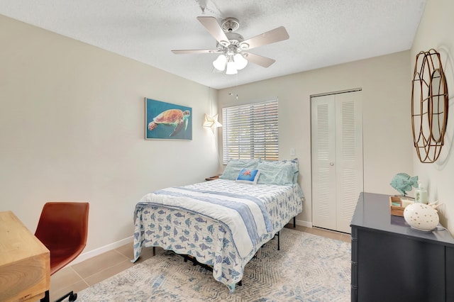 tiled bedroom featuring a textured ceiling, a closet, and ceiling fan