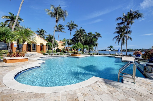 view of pool featuring a water view and a patio area