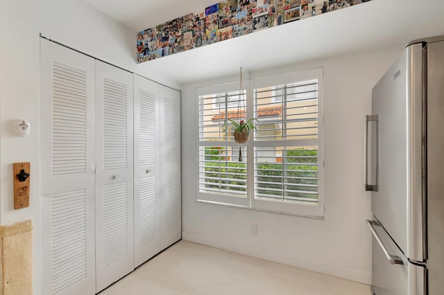 unfurnished bedroom with stainless steel fridge and a closet