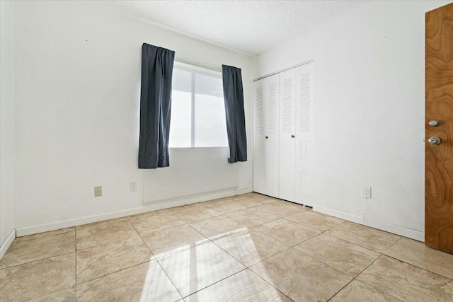 spare room with light tile patterned floors and a textured ceiling