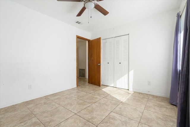 unfurnished bedroom featuring ceiling fan, a closet, and light tile patterned floors