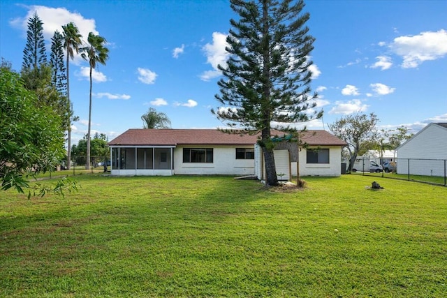 back of property featuring a yard and a sunroom