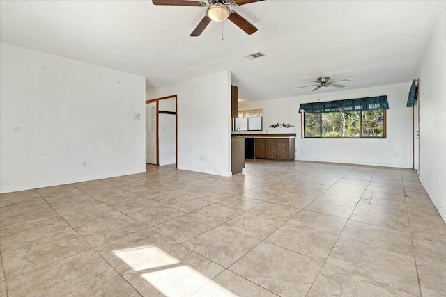 tiled empty room featuring ceiling fan and a textured ceiling