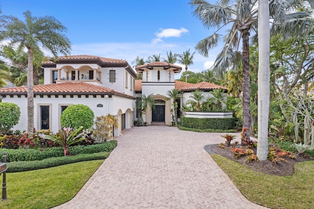 mediterranean / spanish house with a front lawn and a garage