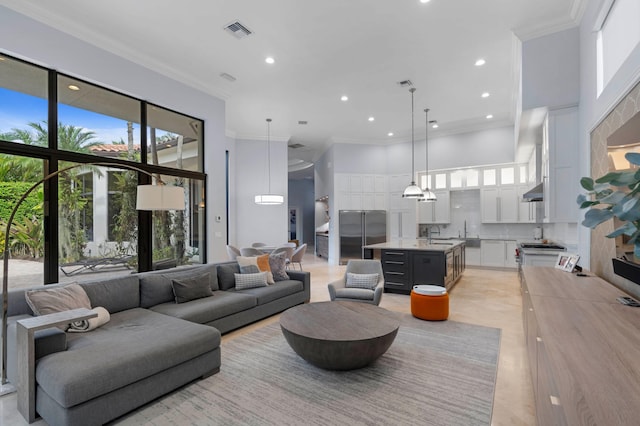 living room featuring a towering ceiling and ornamental molding