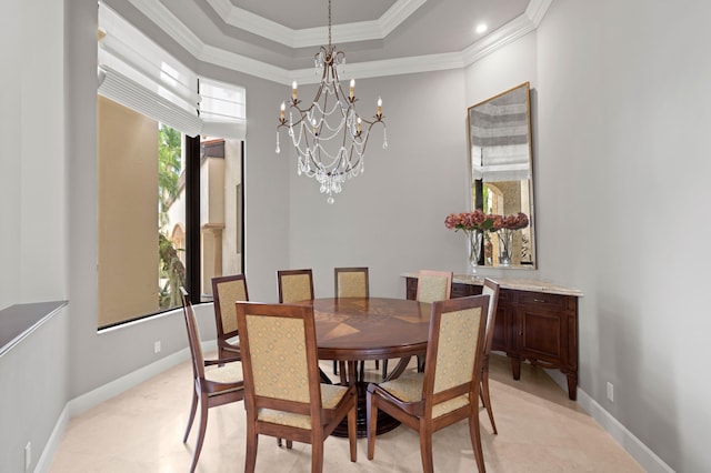 dining room featuring a raised ceiling, a chandelier, and ornamental molding