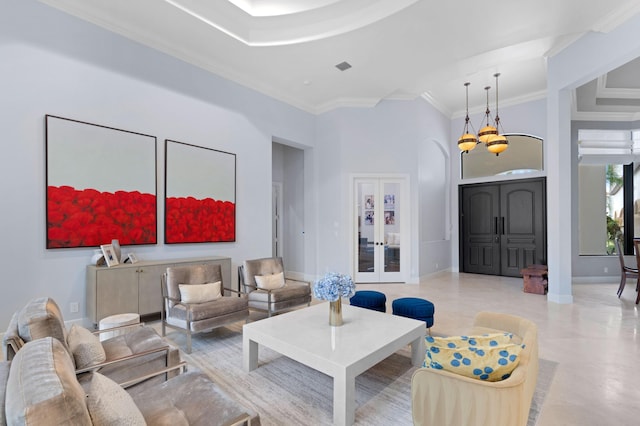 living room with crown molding, a towering ceiling, and a chandelier