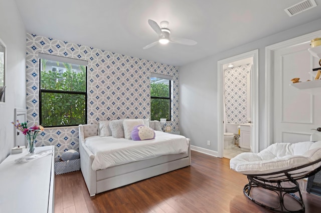 bedroom featuring connected bathroom, ceiling fan, and dark wood-type flooring