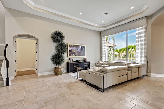 living room featuring a tray ceiling and crown molding