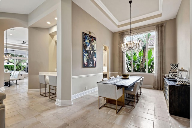 dining room with a raised ceiling, crown molding, and a notable chandelier