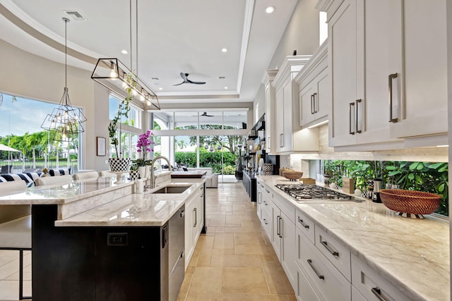 kitchen featuring a tray ceiling, white cabinetry, and pendant lighting