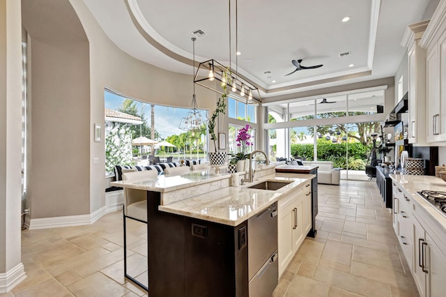 kitchen featuring a center island with sink, white cabinetry, a wealth of natural light, and sink