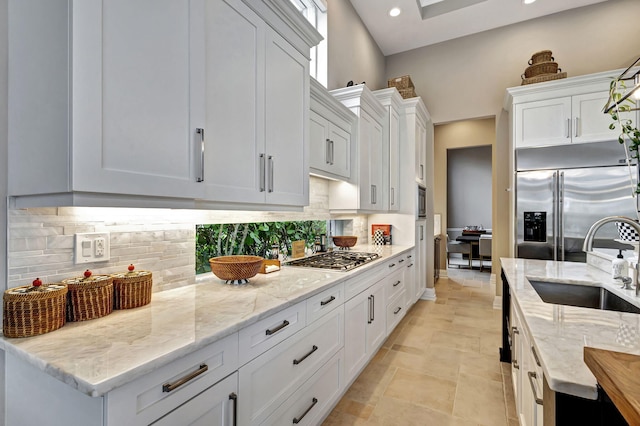 kitchen with white cabinets, light stone countertops, sink, and appliances with stainless steel finishes