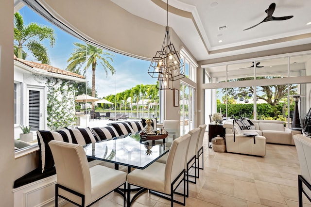 dining area featuring a raised ceiling, ceiling fan, and crown molding