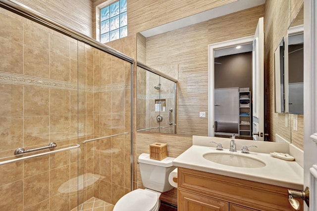 bathroom featuring vanity, toilet, and a shower with door