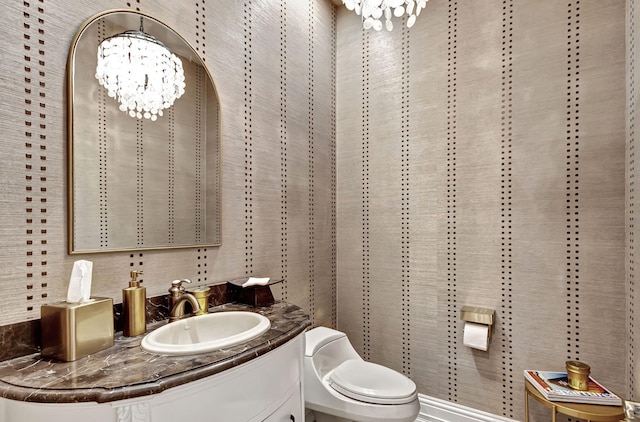 bathroom with vanity, a chandelier, and toilet