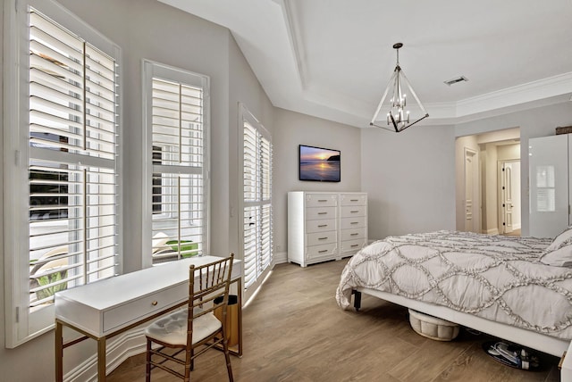 bedroom featuring crown molding, wood-type flooring, and an inviting chandelier