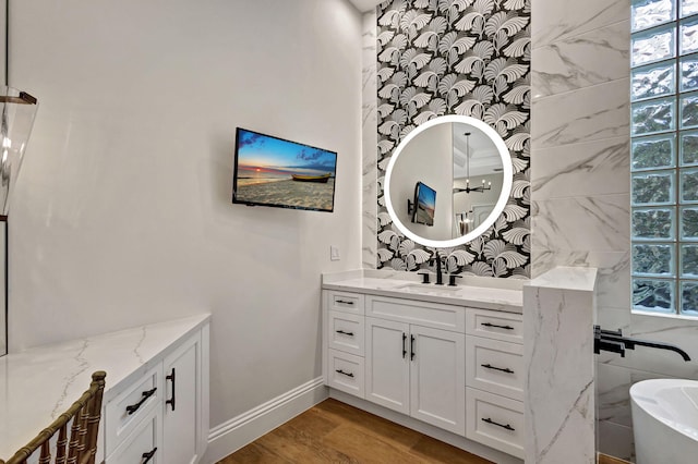 bathroom featuring hardwood / wood-style flooring, vanity, a bathtub, and tile walls