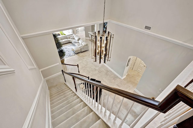 stairway with a notable chandelier