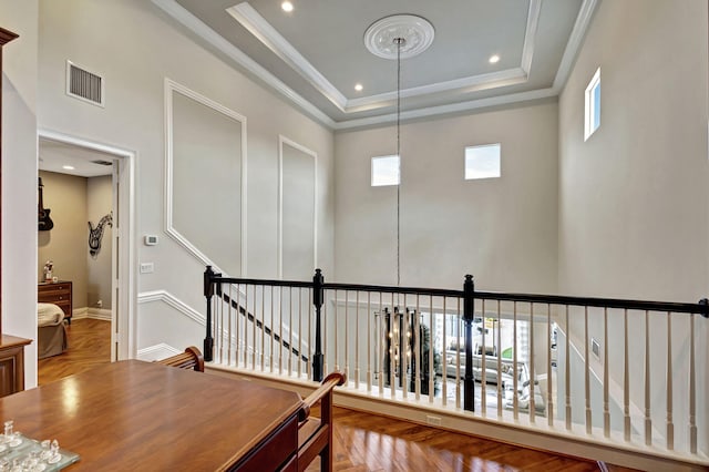 hall featuring a tray ceiling, a wealth of natural light, and parquet flooring