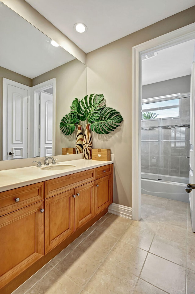 bathroom with tile patterned flooring, vanity, and combined bath / shower with glass door