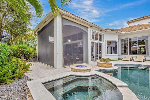 back of house featuring a swimming pool with hot tub and a patio